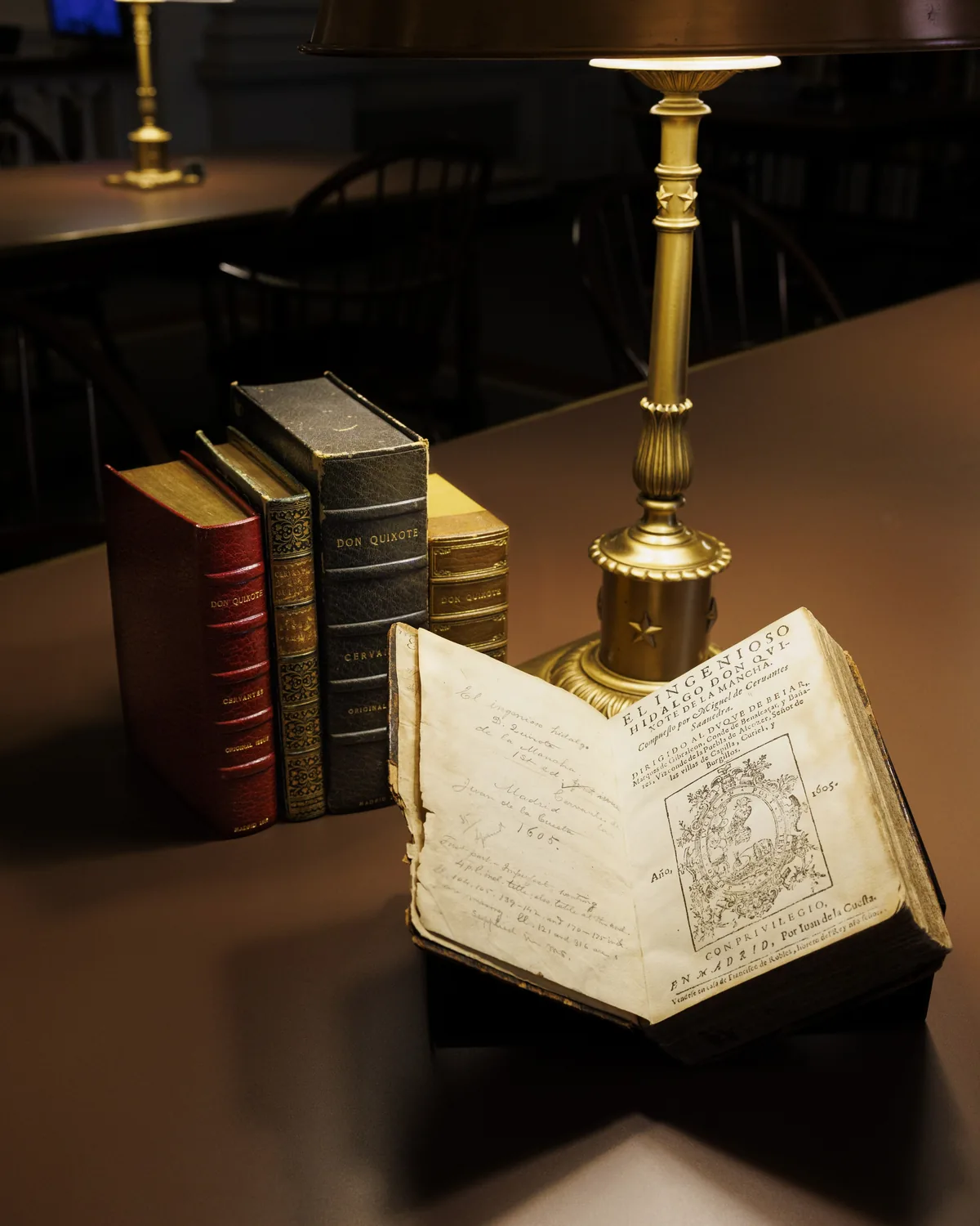 A 1605 first edition of Don Quixote displayed open beneath a reading lamp