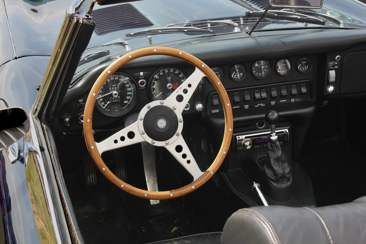 The wood-rimmed steering wheel and instruments of a Jaguar E-Type
