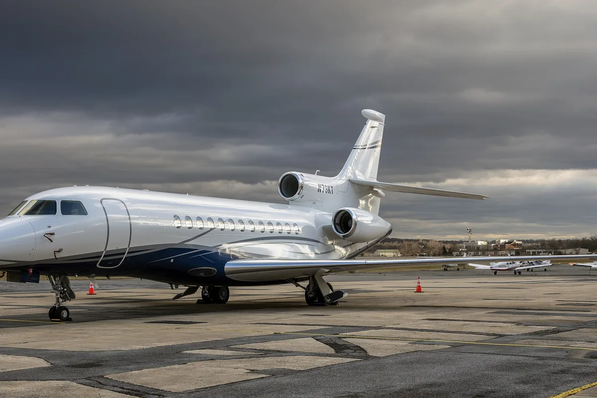 A Dassault Falcon 7X on the apron under a grey evening sky