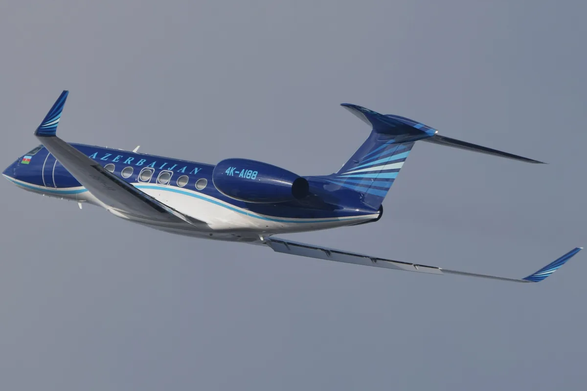 A blue and white Gulfstream G650 business jet banking in flight