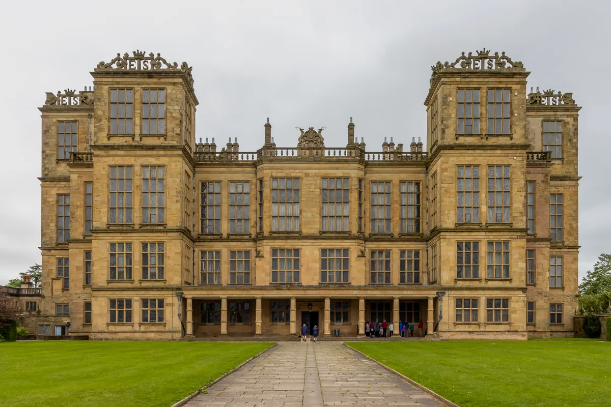 The tall, heavily glazed front of Hardwick Hall in Derbyshire beneath an overcast sky